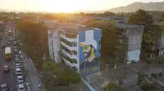 epa11116398 Aerial photograph of a mural alluding to President Nayib Bukele on the facade of a multi-family building, in San Salvador, El Salvador, 31 January 2024. The candidates for the Presidency of El Salvador put an end to a long electoral campaign that began on 03 October 2023 and during which there has hardly been any political debate, largely because the current president Nayib Bukele starts as the great favorite, with more than 80%, according to surveys.  EPA/VLADIMIR CHICAS