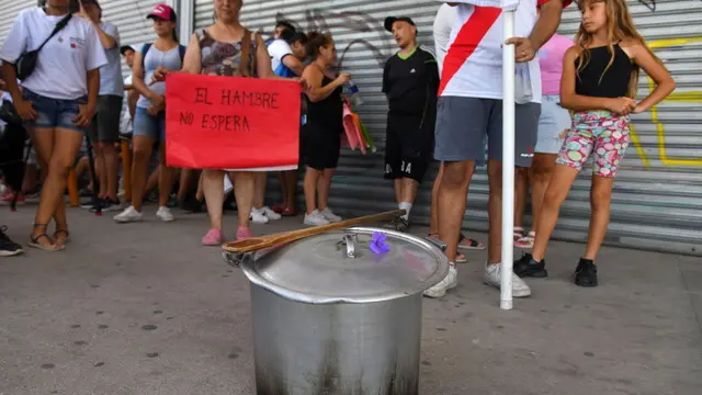 epa11118557 Demonstrators of the UTEP (Union de Trabajadoras y Trabajadores de la Economia Popular) protest in front of the Coto supermarket in Ciudadela, province of Buenos Aires, Argentina, 01 February 2024. The sign reads 'Hunger does not wait.' Popular organizations and social movements march to supermarkets in Argentina to protest against the lack of food assistance to social canteens by the administration of President Javier Milei.  EPA/Enrique Garcia Medina