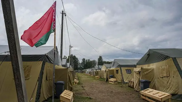 epa10732454 The Belarusian national flag waves near tents at a Belarusian army camp near Tsel village, some 90km southeast of Minsk, Belarus, 07 July 2023. The tent camp, capable of housing up to 5,000 troops, has been offered by Belarus to accommodate the fighters of the Wagner private military company (PMC), Major General Leonid Kasinsky, assistant to the Belarusian Defence Minister said. Belarusian President Lukashenko said he was ready to use Wagner PMC in his country adding that the issue of the private military company's relocation to Belarus was yet to be resolved.  EPA/STRINGER