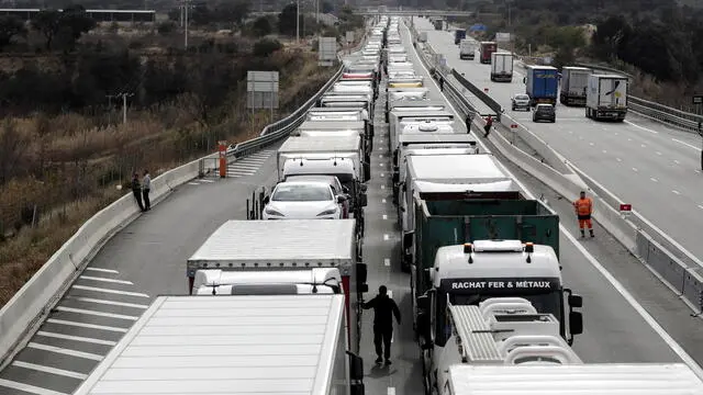 epa11118027 Trucks from Spain wait in a queue as French farmers from the Occitanie region block the A9 motorway at Le Boulou near the Spanish border, Southern France, 01 February 2024. French farmers continue their protests with road blockades and demonstrations in front of state buildings awaiting a response from the government to their request for 'immediate' aid of several hundred million euros. On 23 January, the EU Agriculture and Fisheries Council highlighted the importance of providing the conditions necessary to enable EU farmers to ensure food security sustainably and profitably, as well as ensuring a fair income for farmers. EPA/GUILLAUME HORCAJUELO