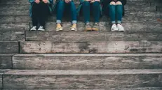 Adolescenti seduti su una scalinata - Foto Unsplash