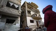 epa11133130 A Palestinian looks at the damaged residential building hosting her family home following overnight Israeli air strikes on the Rafah refugee camp, southern Gaza Strip, 07 February 2024. More than 27,500 Palestinians and over 1,300 Israelis have been killed, according to the Palestinian Health Ministry and the Israel Defense Forces (IDF), since Hamas militants launched an attack against Israel from the Gaza Strip on 07 October 2023, and the Israeli operations in Gaza and the West Bank which followed it.  EPA/HAITHAM IMAD