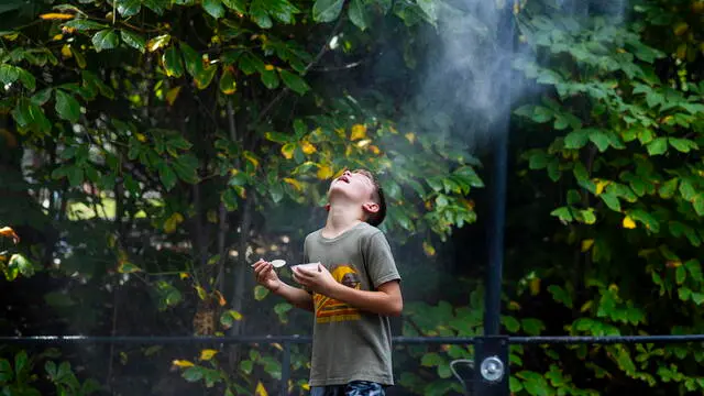 epa10844868 A visitor to the National Zoo cool off in a water mister as the temperature approaches 100 degrees Fahrenheit (38 degrees Celsius) in Washington, DC, USA, 06 September 2023. According to a report released earlier in the day by the United Nation's World Meteorological Organization and the European climate service Copernicus, the three months between June and August 2023 were the hottest ever recorded. EPA/JIM LO SCALZO