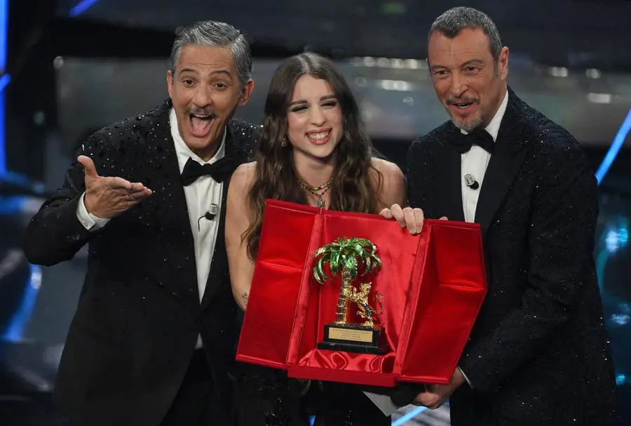 Italian singer Angelina Mango (C) poses with the trophy together with Sanremo Festival co-host and showman Rosario Fiorello (L) and Sanremo Festival host and artistic director Amadeus (R) after winning the Sanremo Italian Song Festival at the Ariston theatre during the 74th Sanremo Italian Song Festival, Sanremo, Italy, 10 February 2024. The music festival will run from 06 to 10 February 2024. ANSA/ETTORE FERRARI