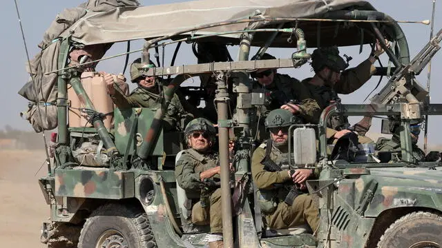 epaselect epa11103117 Israeli soldiers aboard military vehicles transit an area near the border with southern Gaza, at an undisclosed location in southern Israel, 25 January 2024. More than 25,700 Palestinians and at least 1,330 Israelis have been killed, according to the Palestinian Health Ministry and the Israel Defense Forces (IDF), since Hamas militants launched an attack against Israel from the Gaza Strip on 07 October 2023, and the Israeli operations in Gaza and the West Bank which followed it. The Israeli military stated on 25 January that its troops have conducted 'targeted raids on military sites' in the Al Amal area in Khan Yunis, southern Gaza.  EPA/ATEF SAFADI