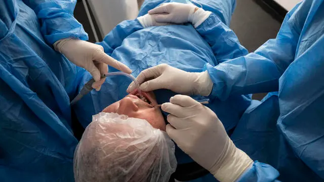 Un paziente nello studio di un dentista vestito con tutta la dotazione obbligatoria come in camera operatoria: salvascarpe, guanti, copricapelli ed in sala di attesa con la mascherina a Roma, 30 aprile 2020.

A patient in the dentist's office dressed in all the compulsory equipment as in the operating room: shoe guards, gloves, headgear and in the waiting room with a mask in Rome, 30 April 2020.
ANSA/LUCIANO DEL CASTILLO