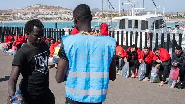 epa11123546 A migrant (L) talks to a Frontex worker upon the arrival of some 54 migrants in Caleta de Fuste, Fuerteventura island, Canary Islands, southwestern Spain, 03 February 2024. EPA/Carlos de Saa