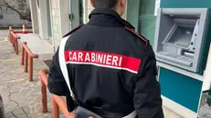 Un carabiniere davanti a uno sportello del bancomat