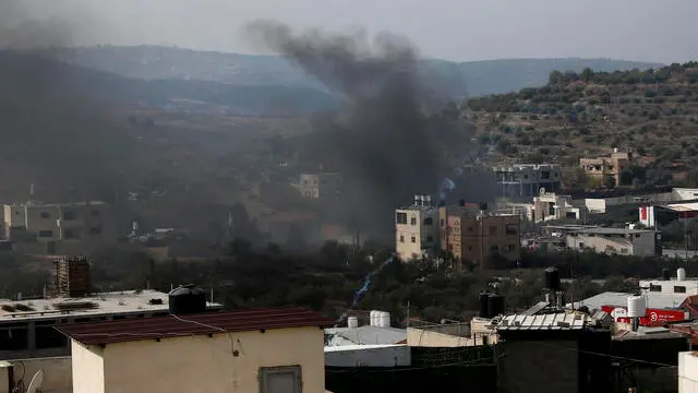 epa10954303 Smoke rises above the town of Deir Sharaf after Israeli settlers attacked the village and set Palestinan cars and shops on fire, near the West Bank city of Nablus, 02 November 2023. The Palestinian ministry puts the death toll of Palestinians in the West Bank at more than 120 Palestinian people and over 2,000 injured between 07 and 30 October, following the escalation of hostilities between Israel and Hamas. EPA/ALAA BADARNEH