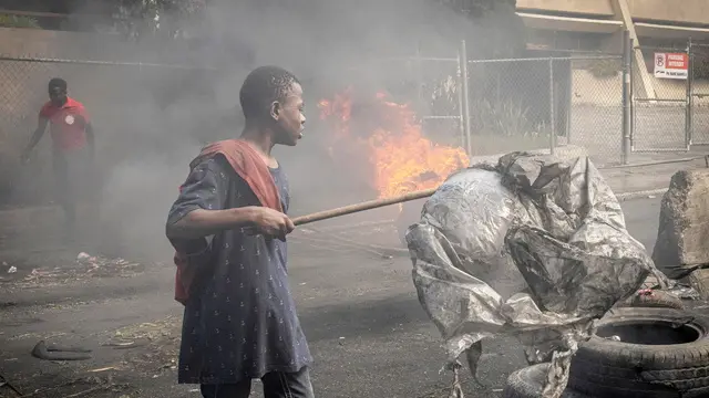 epa11138166 People demonstrate during a protest in Petion-Ville, Haiti, 08 February 2024. The capital of Haiti and several provincial cities are in apparent calm after intense and massive anti-government demonstrations  demanding the resignation of Prime Minister Ariel Henry on 07 February, which left six dead.  EPA/Johnson Sabin