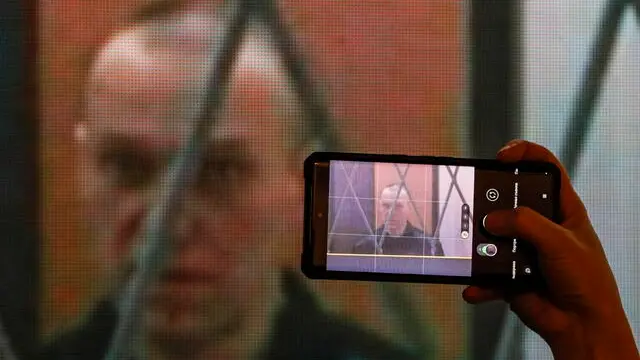 epa11068775 Russian opposition figure Alexei Navalny appears on a screen via a video link during a hearing of the Supreme Court on his claim to declare illegal the provisions of the temporary residence permit, limiting the amount of religious literature, in Moscow, Russia, 11 January 2024. Navalny made his first public appearance since December 2023 in the special regime correctional colony No. 3 'Polar Wolf' in the Yamal village of Kharp. A Russian court extended Navalny's sentence to 19 years in August 2023, on charges of extremism. EPA/YURI KOCHETKOV