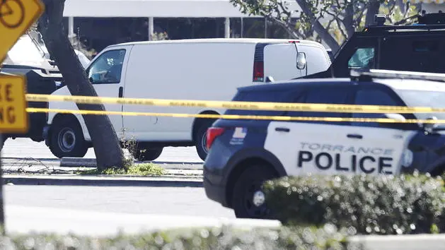 epa10423883 A white van which police reported was connected with a mass shooting at a dance studio in Monterey Park, California, sits trapped between two heavily armored police vehicles in Torrance, California, USA, 22 January 2023. The shooting killed ten and wounded ten more during a Lunar New Year celebration according to the Los Angeles County Sheriff's Department.  EPA/CAROLINE BREHMAN