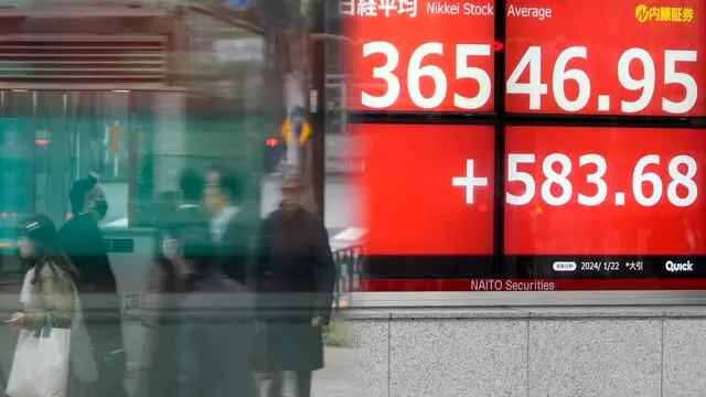 epaselect epa11095466 Passersby walk past a stock market indicator board in Tokyo, Japan, 22 January 2024. Tokyo stock index closed surpassing the 36,000-point mark, pushed by the anticipation that the Bank of Japan would continue its monetary policy. The 225-issue Nikkei Stock Average gained 583.68 points, or 1.62 percent, to close at 36,546.95, its highest level recorded since February 1990.  EPA/FRANCK ROBICHON