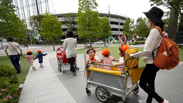 epa09217548 Nursery school toddlers pass past an Olympic Ring monument at Japan Olympic Committee (JOC) headquarters in Tokyo, Japan, 21 May 2021. A three-day meeting of the IOC Coordination Commission for the Games of the XXXII Olympiad were held remotely 19-21 May 2021. The International Olympic Committee, the Tokyo 2020 Organising Committee, the Tokyo Metropolitan Government, the Japanese Olympic Committee, the Government of Japan and other relevant parties participate in the meeting. More than 80 per cent of Japanese people think to cancel or postpone the Tokyo Olympic Games according to a opinion poll by a Japanese TV on mid-May.  EPA/KIMIMASA MAYAMA