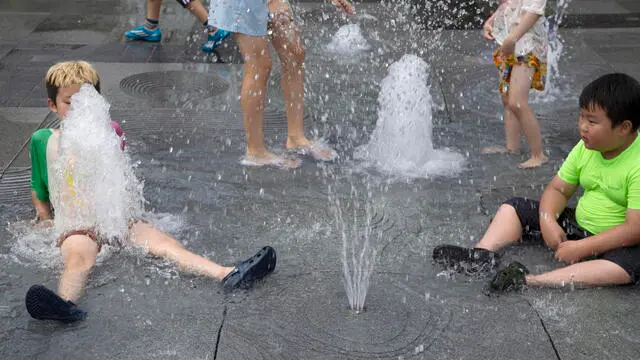 epa10782384 Children cool off in a fountain in Gwanghwamun square in Seoul, South Korea, 03 August 2023. A heat wave continues to affect all areas of South Korea, with temperatures rising to an intraday high of 33 degrees Celsius in Seoul, the South Korean capital. EPA/JEON HEON-KYUN