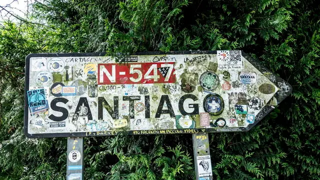 epa10758022 A traffic sign pointing to the City of Santiago de Compostela is placed in O Pino, Galicia, Spain, 09 June 2023. The St James Way, also known as the ‘Way of Saint James’ is one of the most ancient and popular pilgrimage routes in the world since the XI century. Often referred to as the Camino de Santiago, this Way takes pilgrims through many different routes across Spain, France and Portugal and culminates in the city of Santiago de Compostela. EPA/CRISTOBAL HERRERA-ULASHKEVICH ATTENTION: This Image is part of a PHOTO SET