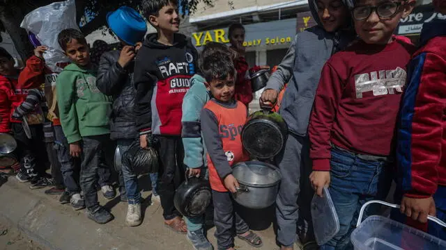 epa11178754 Internally displaced Palestinian children queue up with their pots and containers waiting to receive food provided by Arab and Palestinian donors in Deir Al Balah town, southern Gaza Strip, 24 February 2024. Since 07 October, up to 1.9 million people, or more than 85 percent of the population, have been displaced throughout the Gaza Strip, some more than once, according to the United Nations Relief and Works Agency for Palestine Refugees in the Near East (UNRWA), which added that most civilians in Gaza are in 'desperate need of humanitarian assistance'. EPA/MOHAMMED SABER