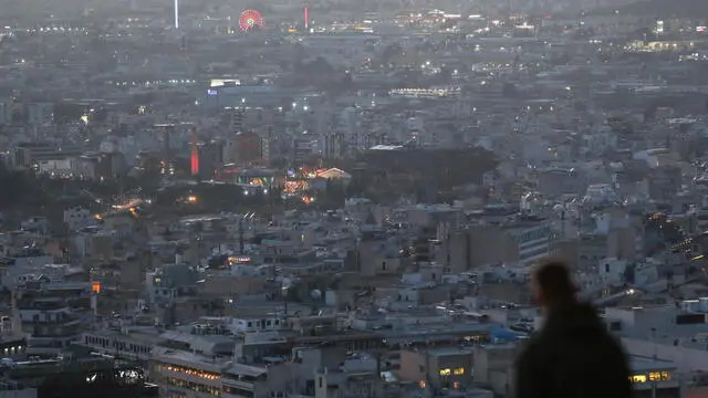 epa11059392 A person on Lycabettus Hill overlooks the city of Athens, Greece, 05 January 2024. EPA/GEORGE VITSARAS