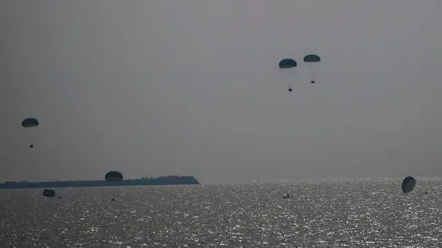 epa11182848 Humanitarian aid is air-dropped by a Jordanian aircraft into the sea off the southern Gaza Strip, 26 February 2024. More than 29,600 Palestinians and over 1,300 Israelis have been killed, according to the Palestinian Health Ministry and the Israel Defense Forces (IDF), since Hamas militants launched an attack against Israel from the Gaza Strip on 07 October 2023, and the Israeli operations in Gaza and the West Bank which followed it. EPA/MOHAMMED SABER