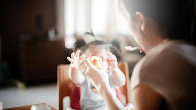 Una mamma dà da mangiare alla figlia - Foto Unsplash