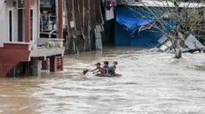 epa08863147 Boys ride on a tube through a flooded residential area in Medan, North Sumatra, Indonesia, 05 December 2020. At least five people died as heavy rains flooded thousands of homes, according to the National Board for Disaster Management (BNPB). EPA/DEDI SINUHAJI