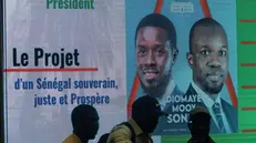 epa11209878 A screen displays photos of Bassirou Diomaye Faye (L) and Ousmane Sonic (R) during the launch of Fayeâ€™s presidential campaign in Dakar, Senegal, 09 March 2024. Faye, of the dissolved party PASTEF, (African Patriots of Senegal for Work, Ethics and Fraternity), is running in place of jailed Senegalese opposition Ousmane Sonko. Sonko and Faye are currently in prison but Faye could be freed soon, according to a recently passed amnesty law for political prisoners. The presidential election will take place on March 24. The vote was originally scheduled for 25 February but outgoing President Macky Sall postponed the elections on account of irregularities in the candidates selection process. The screen reads 'President, the project for a fair and prosperous sovereign Senegal'. EPA/JEROME FAVRE