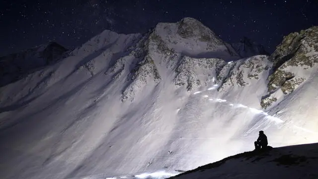 epa09913769 Competitors climb on their way to the 'Col De Tsena Refien' pass under a starry sky, during the 22nd Glacier Patrol race near Arolla, Switzerland, 28 April 2022. The Glacier Patrol (Patrouille des Glaciers in French), organized by the Swiss Army, takes place during the week of 25 April to 01 May. Highly-experienced hiker-skiers trek for over 57,5km (4386m ascent and 4519m descent) along the Haute Route along the Swiss-Italian border from Zermatt to Verbier. EPA/ANTHONY ANEX