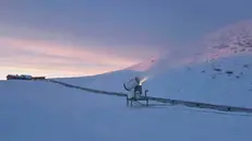 Un cannone per la neve artificiale su una pista da sci