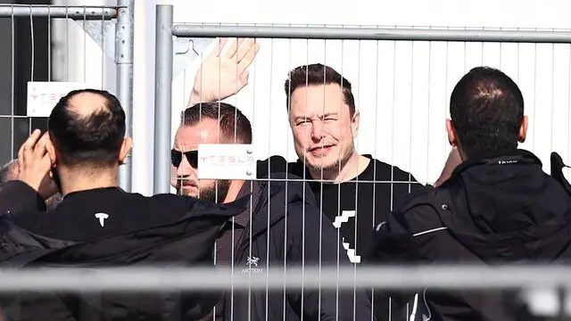 epa11218026 Tesla CEO Elon Musk waves as he arrives for a visit to the electric car plant in Gruenheide near Berlin, Germany, 13 March 2024. Musk is in Germany to visit Tesla's gigafactory at Gruenheide after an arson attack on a nearby power pylon last week left it without electricity and halted production. EPA/FILIP SINGER -- BEST QUALITY AVAILABLE
