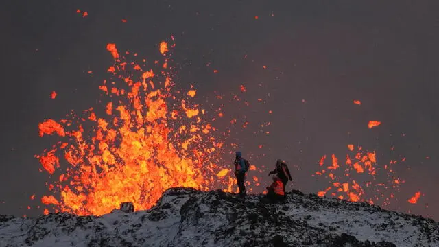 epa11037614 A team of scientists works on the ridge of a volcanic fissure as lava spews during a volcanic eruption, near the town of Grindavik, in the Reykjanes peninsula, southwestern Iceland, 19 December 2023. The Icelandic Meteorological Office (IMO) announced the start of a volcanic fissure eruption near the Sundhnuka crater, north-east of Grindavik, on the night of 18 December, following weeks of intense earthquake activity in the area. The power and seismic activity of the eruption have decreased over time, IMO reported on 19 December, adding that since the eruption began, about 320 earthquakes have been recorded. EPA/ANTON BRINK
