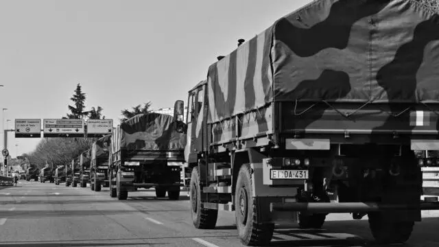 Nella foto: Il secondo intervento militare per lo smistamento delle bare accumulate al cimitero della città prendono il via sui mezzi militari con destinazioni altri forni crematori. Bergamo 21 Marzo 2020 Tiziano Manzoni/© In the photo: The second military intervention for the sorting of the coffins accumulated in the cemetery of the city starts on military vehicles with destinations other crematoria. Bergamo 21 March 2020 Tiziano Manzoni / ©