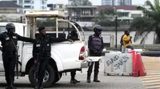 epa09534459 Policemen stand guard near a vehicle parked by a sign on a platform during a memorial protest for a military attack at the Lekki tollgate in Lagos, Nigeria, 20 October 2021. Police dispersed youths who held a memorial protest in Lagos to commemorate a military attack during the protest against police brutality on 20 October 2020. EPA/AKINTUNDE AKINLEYE