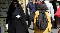 epa10858499 Veiled Iranian woman walks next to a girl without the mandatory headscarf, in a street in Tehran, Iran, 13 September 2023. Iranians are marking the first anniversary of Mahsa Amini's death which led to nationwide protests over the country's mandatory dress code (Hijab) law. Protests erupted after the death of 22-year old Iranian woman, Mahsa Amini, detained by morality police for not wearing the hijab properly in September 2022. Since then, a growing number of women in the country have been defying authorities by removing the headscarf. EPA/ABEDIN TAHERKENAREH