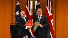 epa11232575 Secretary of State for Defence of the United Kingdom Grant Shapps (L) and Australian Defence Minister Richard Marles exchange Defence Treaty documents during a meeting for annual defence and security talks at Parliament House in Canberra, Australia, 21 March 2024. EPA/LUKAS COCH AUSTRALIA AND NEW ZEALAND OUT