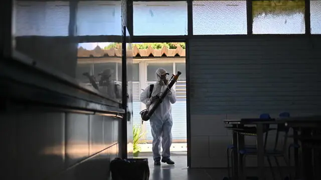 epa11228666 A worker fumigates a classroom at a school to prevent the proliferation of the dengue-transmitting mosquito Aedes aegypti, on 16 March 2024, in the administrative region of Ceilandia, in Brasilia, Brazil (issued 18 March 2024). Brazil broke the historical record of dengue cases on 18 March, with more than 1.88 million infections in just over two and a half months compared to 1.68 in all of 2015, the year that had the maximum number of records until date. The country already exceeds the total reported in the previous record year by 200,000 cases, according to data released by the Ministry of Health, which represents a new milestone for a disease on the rise due to climate change. EPA/ANDRE BORGES