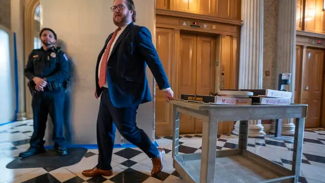 epa11237169 A Senate staff member wheels a cart of pizzas near the Senate floor as conversations continue on the USD 1.2 trillion government funding package at the US Capitol in Washington, DC, USA, 22 March 2024. Conversations continue in the Senate toward a vote on the USD 1.2 trillion spending package passed by the House to prevent a partial shutdown of key government agencies. EPA/SHAWN THEW