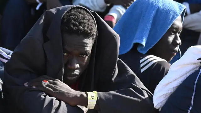 A migrant waits in line outsidewait the hotspot to be transferred to other places from the Lampedusa's island southern Italy, 15 September 2023. A record number of migrants and refugees have arrived on the Italian island of Lampedusa in recent days. Lampedusa's city council declared a state of emergency on 13 September evening after a 48-hour continuous influx of migrants. In the morning of September 14, nearly 7,000 migrants were on the island. ANSA/CIRO FUSCO