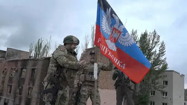 epa10648900 A still image taken from a handout video made available by Denis Pushilin, head of the self-proclaimed Donetsk People's Republic (DPR) telegram channel shows Denis Pushilin (L) installing a DPR flag atop of a damaged building in Bakhmut, eastern Ukraine, 23 May 2023. The Russian-backed official visited Bakhmut to inspect the settlement. The frontline city of Bakhmut, a key target for Russian forces, has seen heavy fighting for months. On 24 February 2022 Russian troops entered the Ukrainian territory in what the Russian president declared a 'Special Military Operation', starting an armed conflict that has provoked destruction and a humanitarian crisis. EPA/HEAD OF THE DONETSK PEOPLE'S REPUBLIC HANDOUT -- MANDATORY CREDIT -- BEST QUALITY AVAILABLE -- HANDOUT EDITORIAL USE ONLY/NO SALES