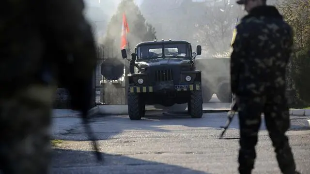 epa04136619 Ukrainian soldiers stand guard as Crimea's self-defense units storm the Belbek Air Force base in Belbek, Ukraine, 22 March 2014. Belbek was the last Ukrainian military base, which has not surrendered after the annexation of Crimea by Russia. Crimean Premier Sergey Aksenov stressed that the base had been liberated from 'foreign troops'. In recent days, Russia has sought to clear out the last few pockets of resistance by browbeating dispirited Ukrainian troops into surrender. EPA/JAKUBI KAMINSKI POLAND OUT