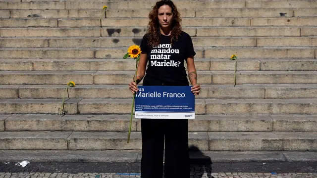 epa11220137 Monica Benicio, the widow of Brazilian councilor Marielle Franco, poses with a sign and a t-shirt with the message 'Who ordered Marielle to be killed?' during an event to demand justice for her murder, on the sixth anniversary of her death, on the steps of the Municipal Chamber of Rio de Janeiro, Brazil, 14 March 2024. Dozens of people gathered in front of the Municipal Chamber of Rio to ask for clarification on the murder case of the activist Marielle Franco, who was killed in Rio de Janeiro on 14 March 2018 alongside her driver Anderson Gomes. Although the alleged perpetrators are in prison, it is unknown who ordered the homicide and for what reason. EPA/Antonio Lacerda