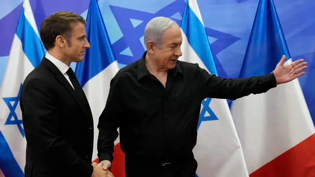 epa10935441 Israeli Prime Minister Benjamin Netanyahu (R) welcomes French President Emmanuel Macron before their talks in Jerusalem, 24 October 2023. Macron is traveling to Israel to show France's solidarity with the country and further work on the release of hostages who are being held in Gaza. EPA/CHRISTOPHE ENA / POOL MAXPPP OUT