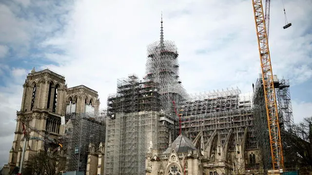 epa11150352 Reconstruction workers start to remove the scaffolding around the spire of Notre Dame in Paris, France, 13 February 2024. After the collapse of the spire in the 15 April 2019 Notre-Dame fire, it was decided to rebuild it identically. The reopening of the medieval Catholic cathedral on the Ile de la Cite island in the Seine river is planned for the end of 2024. EPA/YOAN VALAT