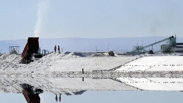 epa03409200 A photograph dated 22 June 2012 made available on 24 September 2012 of workers standing at the salt evaporation pools of the Lithium Society of Lithium, in Atacama, near Calama city, 1,750 km north of Santiago, Chile. The Sociedad Quimica y Minera de Chile (SQM) company, a producer of iodine and lithium, won the open tender process by the Chilean government for the exploitation of lithium deposits in the north of the country, with an offer of 40.6 million US dollars, according to official sources on 24 September 2012. SQM has operations in several countries such in Europe, America, Asia and Oceania. EPA/ARIEL MARINKOVIC