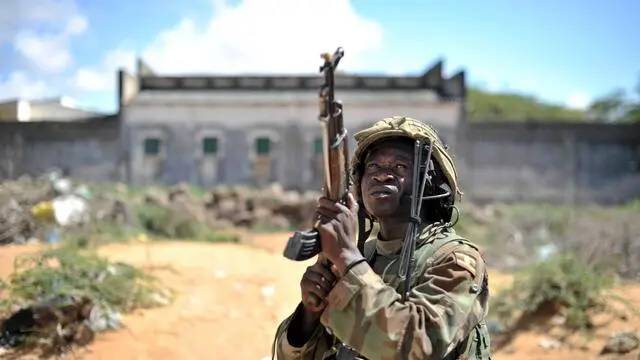 epa04434804 A handout photograph made available by the African Union-United Nations Information Support Team (AU-UN IST) shows a member of the Ugandan Special Forces, part of a joint Somali National Army and African Union Mission in Somalia (AMISOM) force taking part in an operation to clear a suspected building during the second phase of Operation Indian Ocean which captured from the extremist group Al Shabab the town of Barawae, Lower Shabelle region of Somalia, 06 October 2014. According to reports a joint military operation between AMISOM and the Somali Army met minimal resistance as they retook the strategically important port town of Barawe 05 October, 200km from the Somali capital Mogadishu, previously held by the Somali militant group al-Shabab since 2006 and used by them to bring in weapons and fighters from abroad, and support their cause through exports. EPA/AMISOM PHOTO / TOBIN JONES / HANDOUT HANDOUT EDITORIAL USE ONLY/NO SALES HANDOUT EDITORIAL USE ONLY/NO SALES