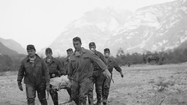 Vigili del fuoco trasportano cadaveri in una foto del 1963 - © www.giornaledibrescia.it