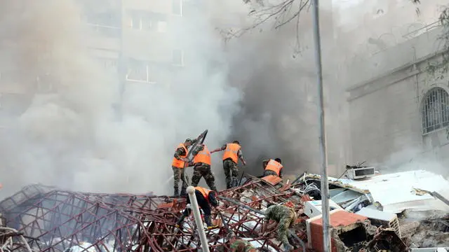 epa11254834 Rescue workers at the site of an airstrike in Damascus, Syria, 01 April 2024. According to the Syrian Arab News Agency SANA, Israel on 01 April launched an airstrike targeting the Iranian consulate building in Damascus. The consulate was damaged while the building next to it was destroyed. EPA/YOUSSEF DAFAWWI