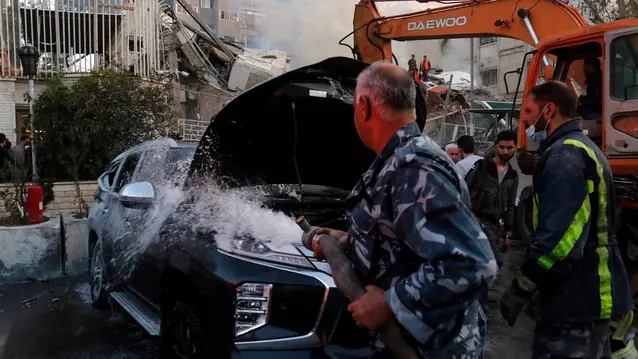 epa11254845 A damaged vehicle is doused following an airstrike next to the Iranian consulate in Damascus, Syria, 01 April 2024. According to the Syrian Arab News Agency SANA, Israel on 01 April launched an airstrike targeting the Iranian consulate building in Damascus. The consulate was damaged while the building next to it was destroyed. EPA/YOUSSEF DAFAWWI