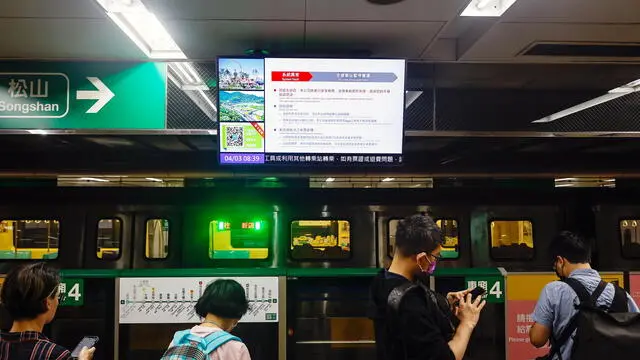 epa11256370 Passengers wait below a screen broadcasting a subway train suspension announcement following a magnitude 7.4 earthquake near Hualien, in a subway station in Taipei, Taiwan, 03 April 2024. A magnitude 7.4 earthquake struck Taiwan on the morning of 03 April with an epicentre 18 kilometres south of Hualien City at a depth of 34.8 km, according to the United States Geological Survey (USGS). EPA/DANIEL CENG