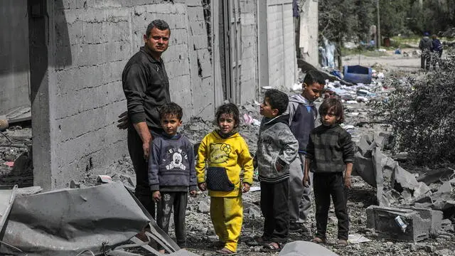 epa11249344 A Palestinian man and children from the Moussa family stand among the rubble of their destroyed home following an Israeli air strike, in Al-Maghazi refugee camp, southern Gaza Strip, 29 March 2024. According to the Palestinian Civil Defence, a strike hit a residential building in the Al-Maghazi refugee camp, killing more than 10 Palestinians, most of them displaced, while at least 15 others are still buried under the rubble. More than 32,500 Palestinians and over 1,450 Israelis have been killed, according to the Palestinian Health Ministry and the Israel Defense Forces (IDF), since Hamas militants launched an attack against Israel from the Gaza Strip on 07 October 2023, and the Israeli operations in Gaza and the West Bank which followed it. EPA/MOHAMMED SABER