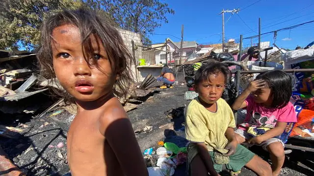 epa11255124 Children sit near damaged houses of a residential district following a fire in Las Pinas city, Metro Manila, Philippines, 02 April 2024. According to a report by the Philippines Bureau of Fire Protection (BFP), fire incidents between January and March are higher by 24 percent over the same period in 2023. Firefighters experienced a sharp increase in calls from households due to power overload and overheating of electric fans from non-stop usage, leading to fires. EPA/FRANCIS R. MALASIG